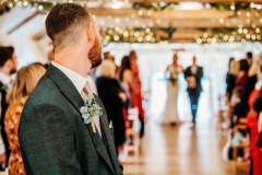 Bride comes down the aisle in the wedding barn