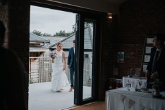 This black and white photo shows the couple framed in the doorway to the Red Brick Barn. They are about to enter the Red Brick Barn to join their guests for the wedding breakfast