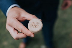 A close up of a man\'s hand holding a small round ring box