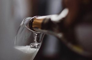 A bottle of champagne being poured into a champagne flute