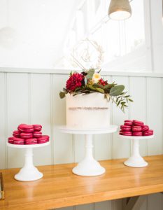 White cake with two cake stands of pink macaroons